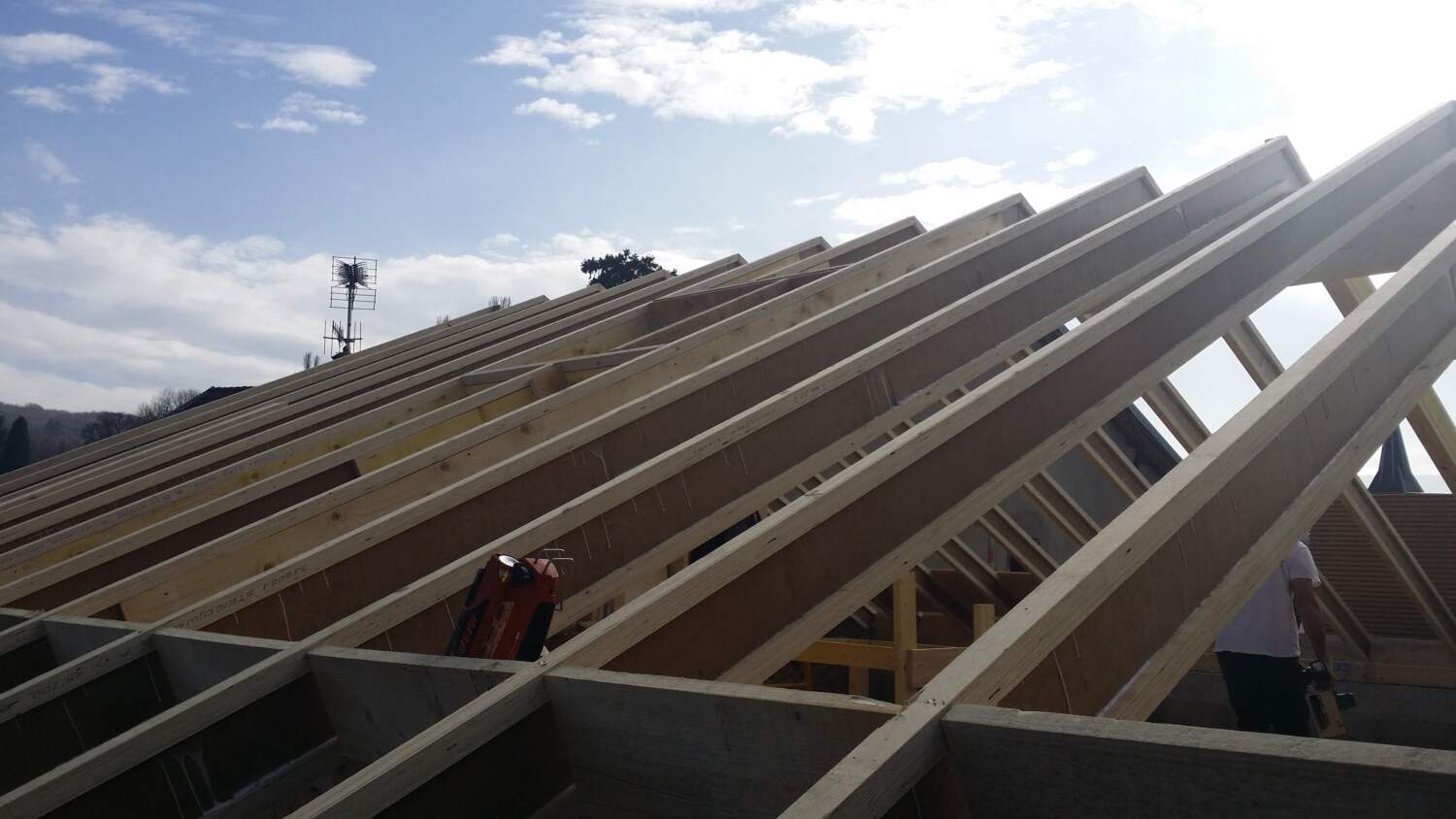 Charpentiers installant des fermes de toit sur un chantier de construction.