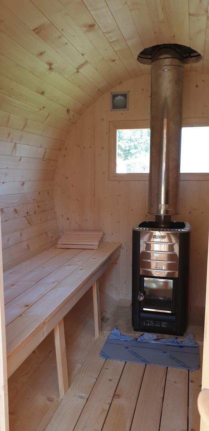 Charpentier installant un poêle à bois à l'intérieur d'un chalet.