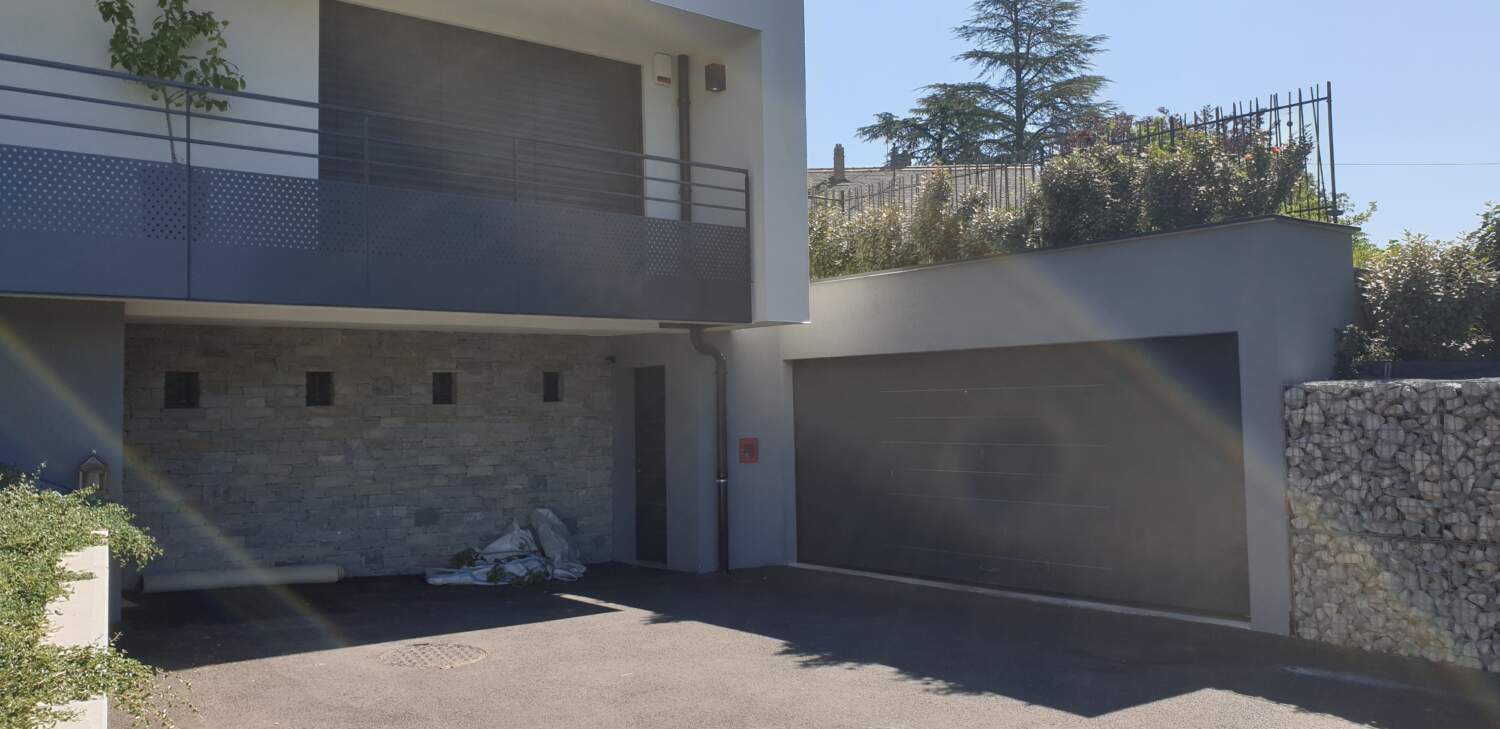 Installation de porte de garage sur un chantier de construction résidentiel.