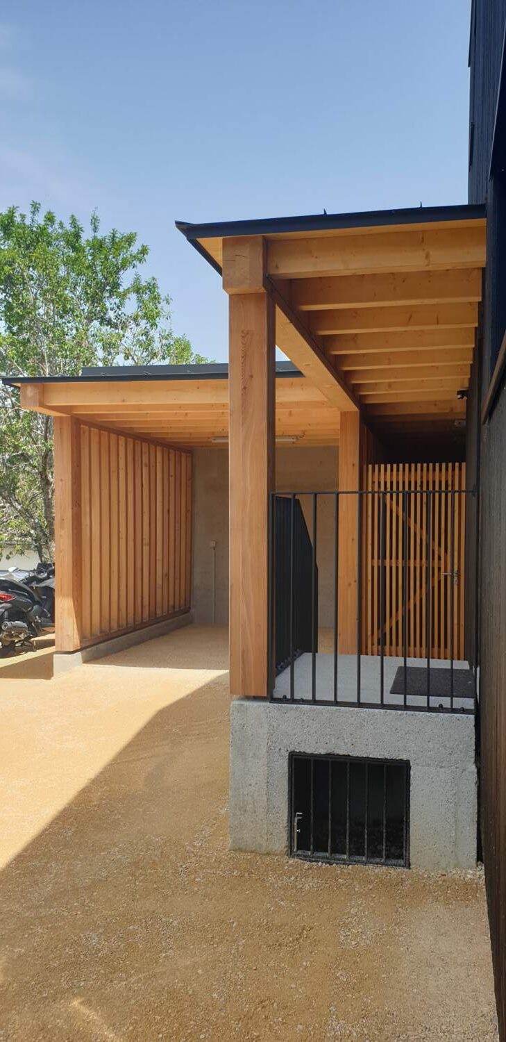 Charpentier installant un bardage en bois sur l'extérieur d'une maison.