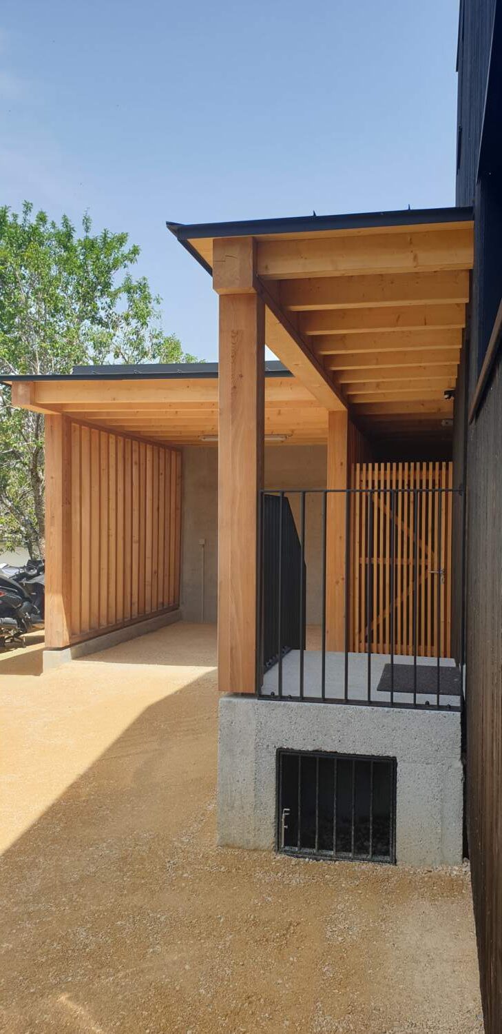 Charpentier installant une pergola en bois sur un chantier de construction.