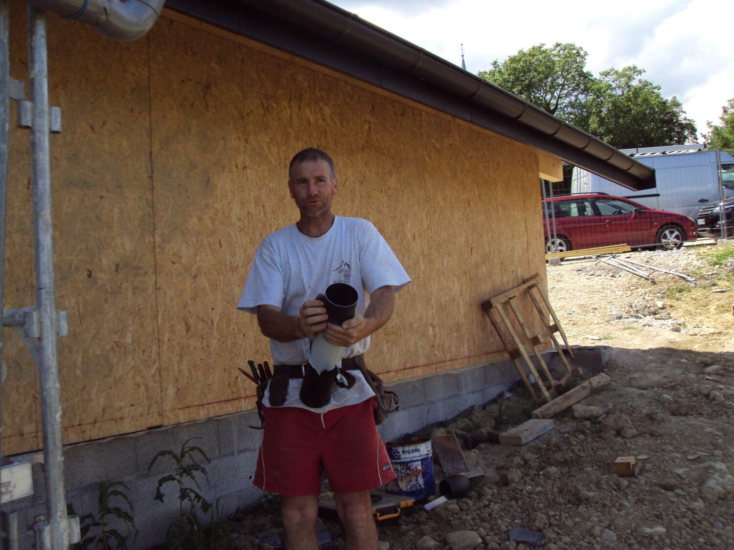 Charpentier sur un chantier de construction avec une tasse de café.
