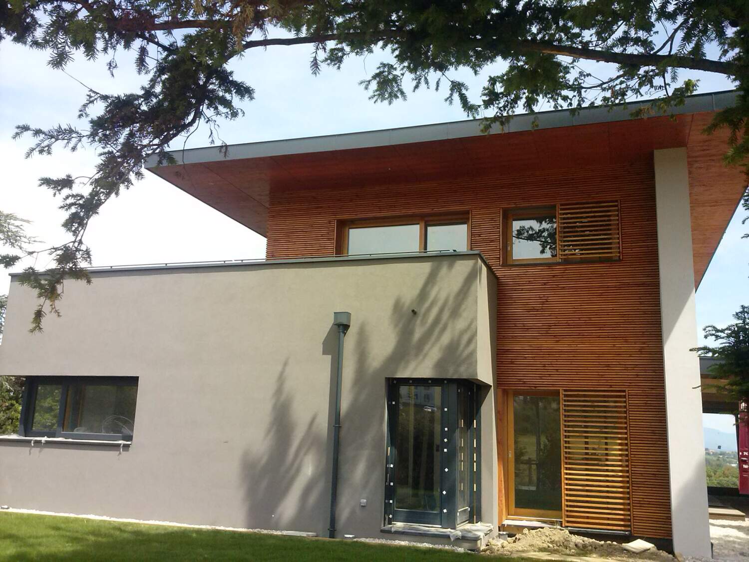 Maison moderne avec menuiserie en bois et grandes fenêtres.