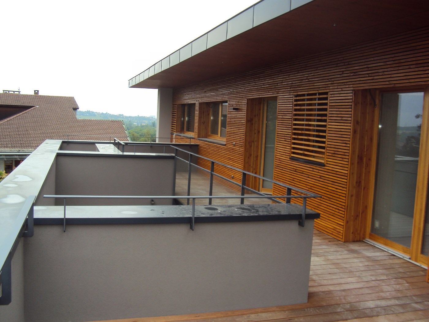 Charpentier installant un bardage en bois sur l'extérieur d'une maison.