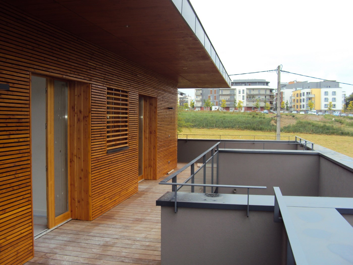Installation de bardage en bois sur l'extérieur d'un bâtiment résidentiel.
