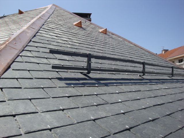 Installation d'une toiture en ardoise sur un chantier de construction.