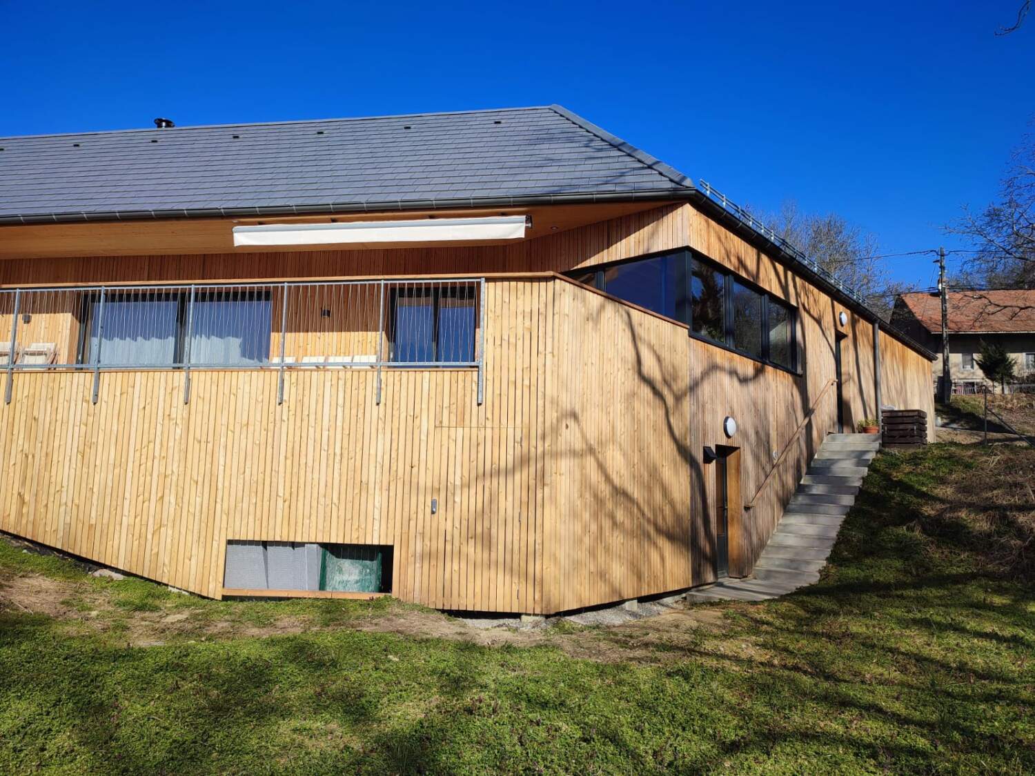 Installation de bardage en bois sur l'extérieur d'une maison.