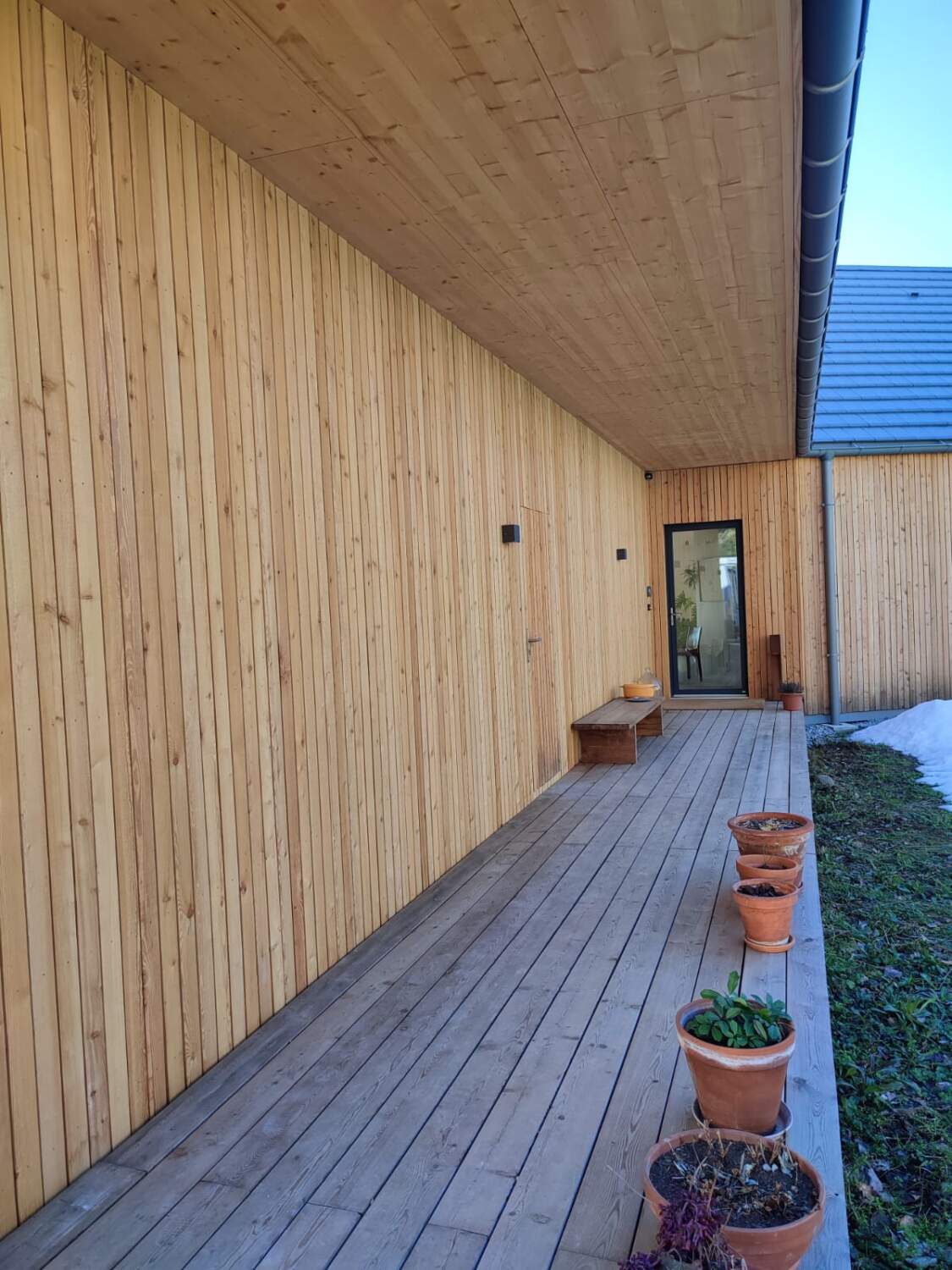 Installation de bardage en bois sur l'extérieur d'une maison.