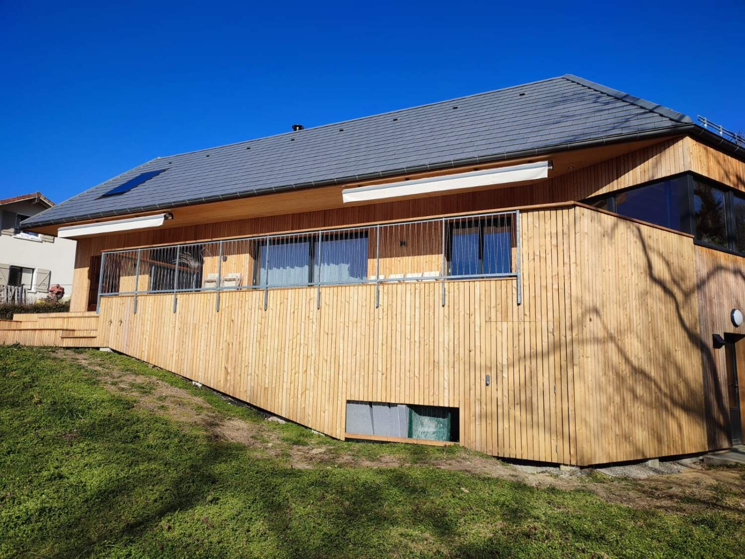 Installation de bardage en bois sur l'extérieur d'une maison.