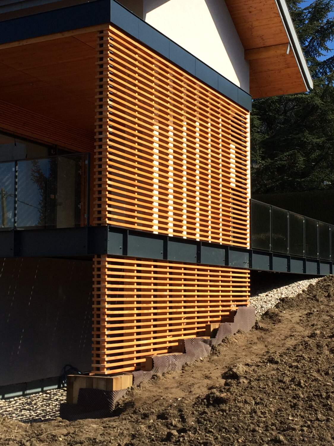 Installation de bardage en bois sur l'extérieur d'une maison.
